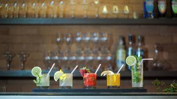 A bar counter with a selection of drinks and a backdrop of neatly arranged glasses.