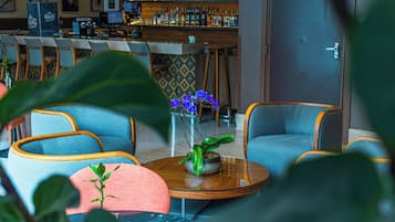 Un espace bar comprenant un comptoir, des tabourets de bar et une variété de bouteilles.