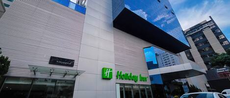 Un edificio moderno con un llamativo letrero de 'Holiday Inn'.