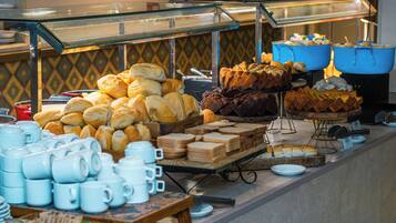 A buffet with various food items and utensils.