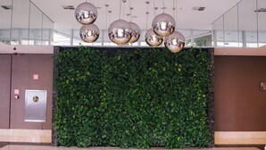 A lobby with a green wall, a metallic spherical light fixture, and a security keypad.