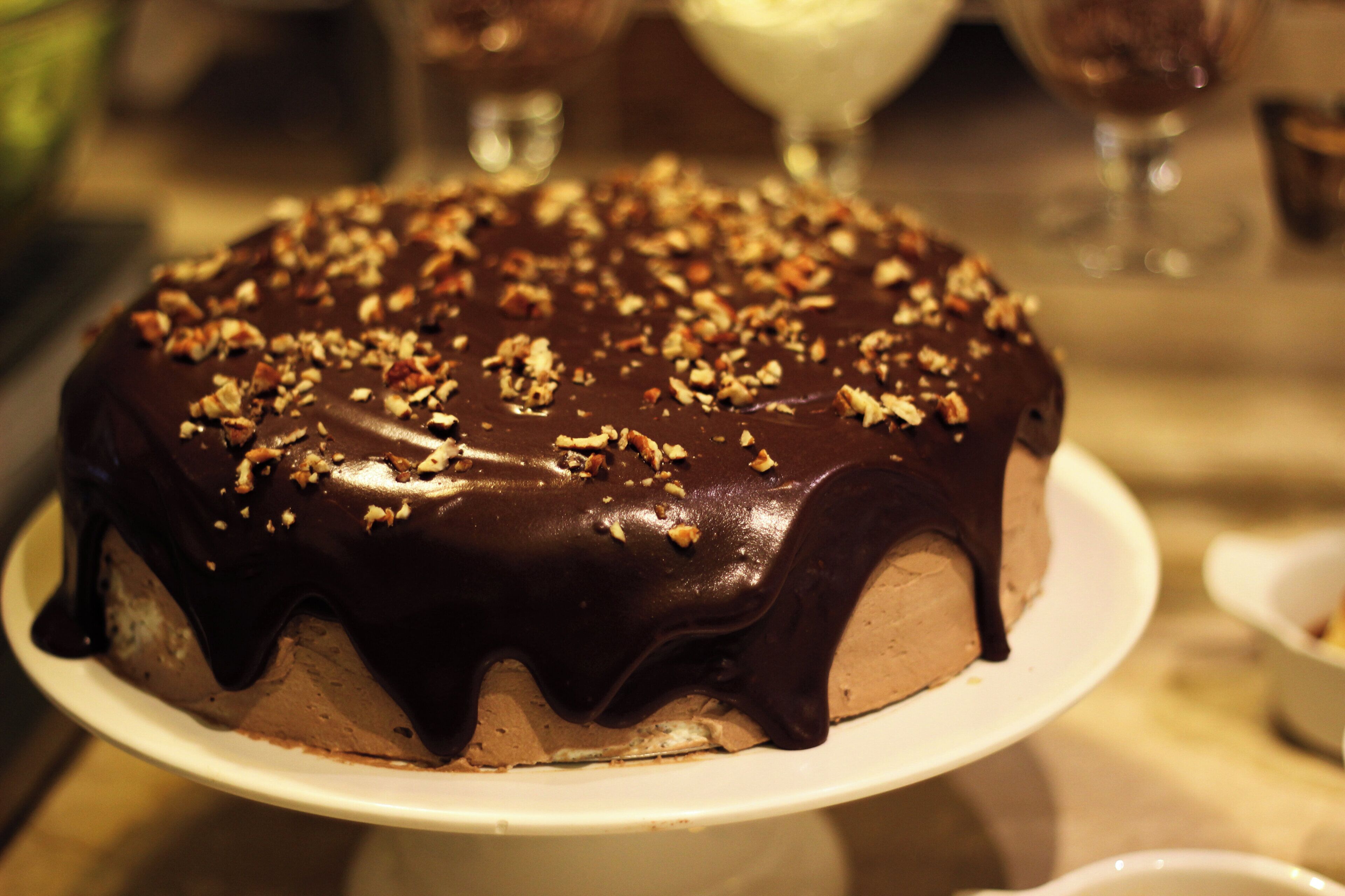 Un pastel de chocolate con nueces sobre un plato blanco.