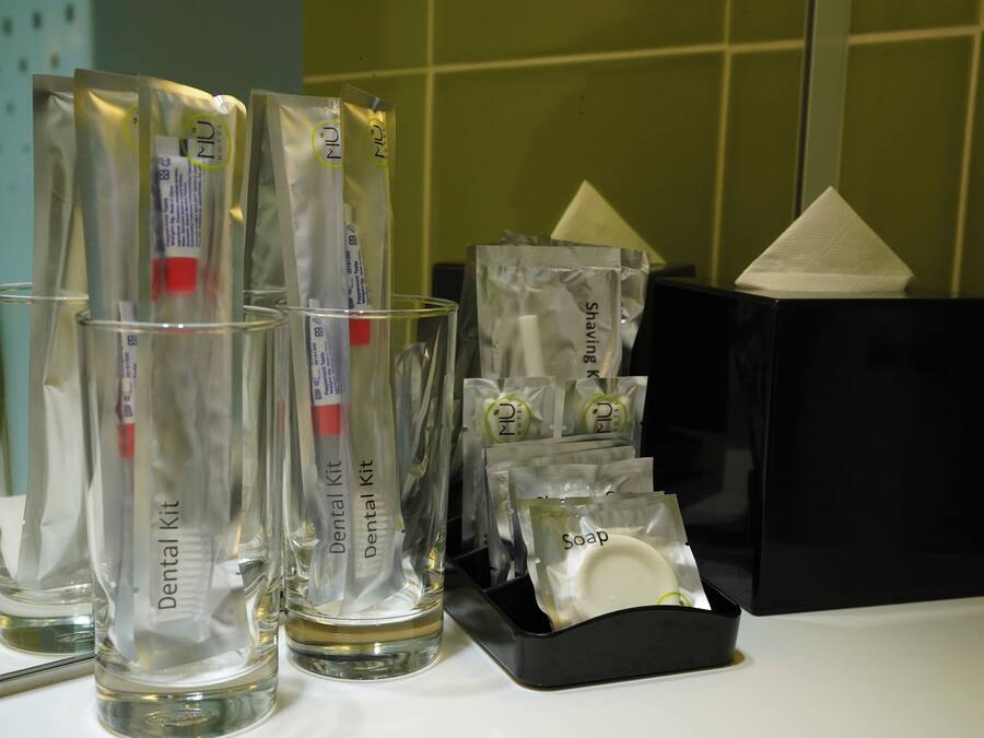 Une trousse de soins dentaires contenant divers articles, notamment des brosses à dents, du dentifrice et du fil dentaire, le tout rangé avec soin dans un étui.