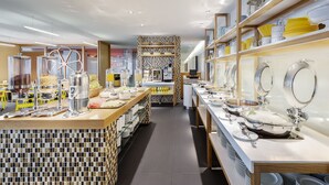 Cocina moderna y bien iluminada con electrodomésticos de acero inoxidable, encimeras de madera y utensilios ordenados.