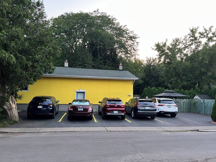 A yellow building with a garage parking area.