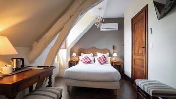 Ein Schlafzimmer mit einem Bett, Nachttischen, einer Holzbank, einem Heizkörper und einer Chandelieber.