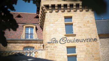 Un edificio de piedra con el letrero "La Couleuvrine", que indica un hotel u establecimiento similar.