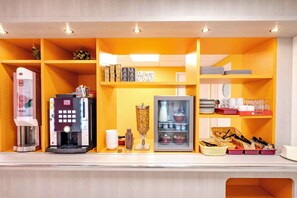 A kitchenette with a coffee machine, a blender, a refrigerator, and various kitchen utensils and containers. - Premiere Classe Roissy - Aéroport CDG - Le Mesnil Amelot (Le Mesnil-Amelot)