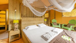 Une pièce en bois avec un lit, une table de chevet, une lampe et une chaise.