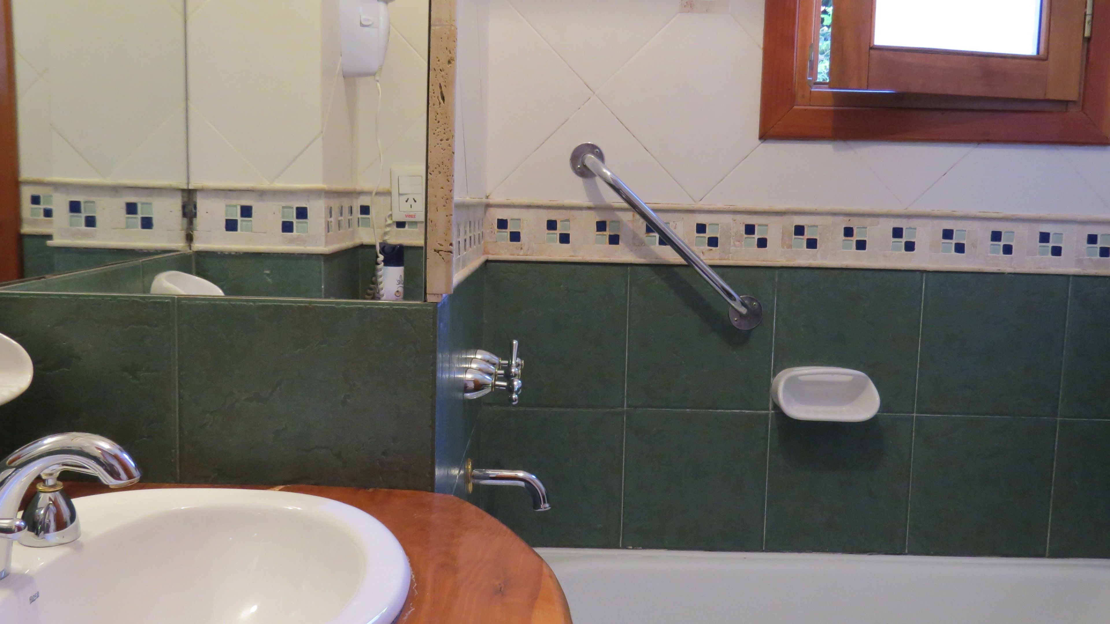 Uma casa de banho com lavatório, espelho e banheira.