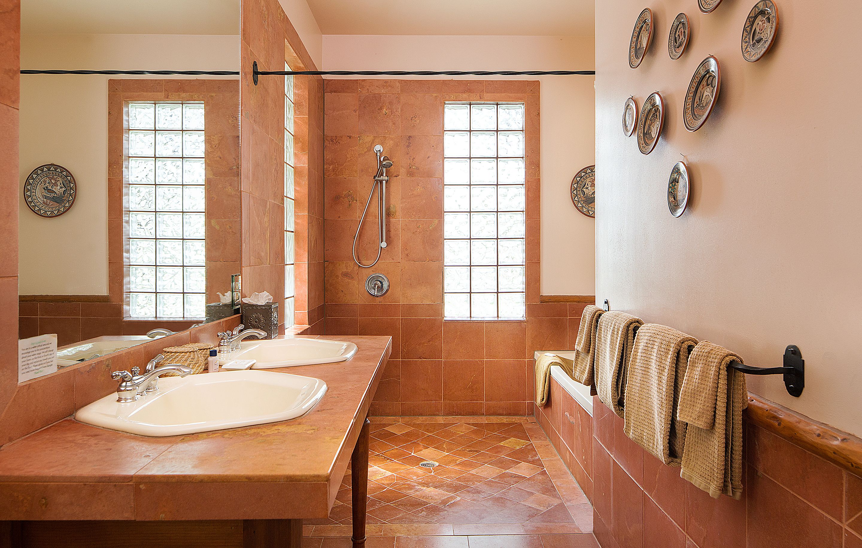 A bathroom with two sinks, a shower, and a towel rack.