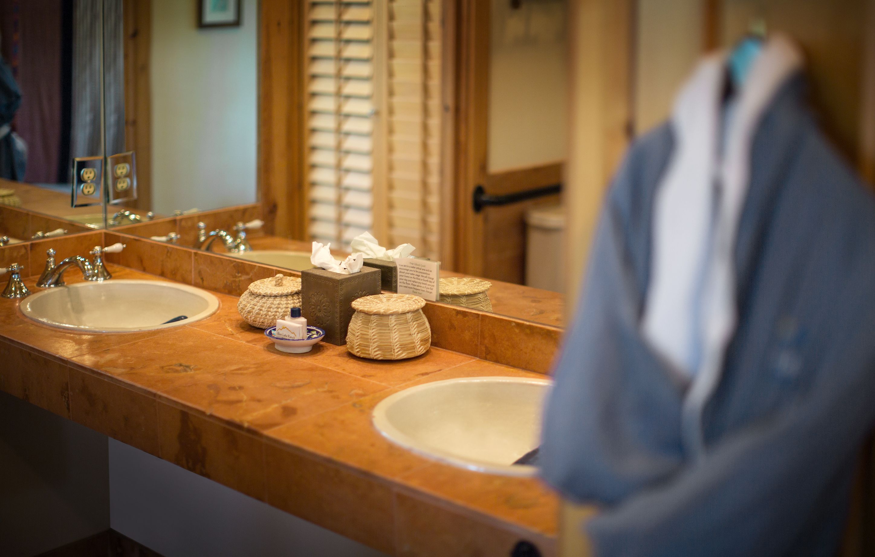 Une salle de bain avec deux lavabos, un miroir et un porte-serviettes.