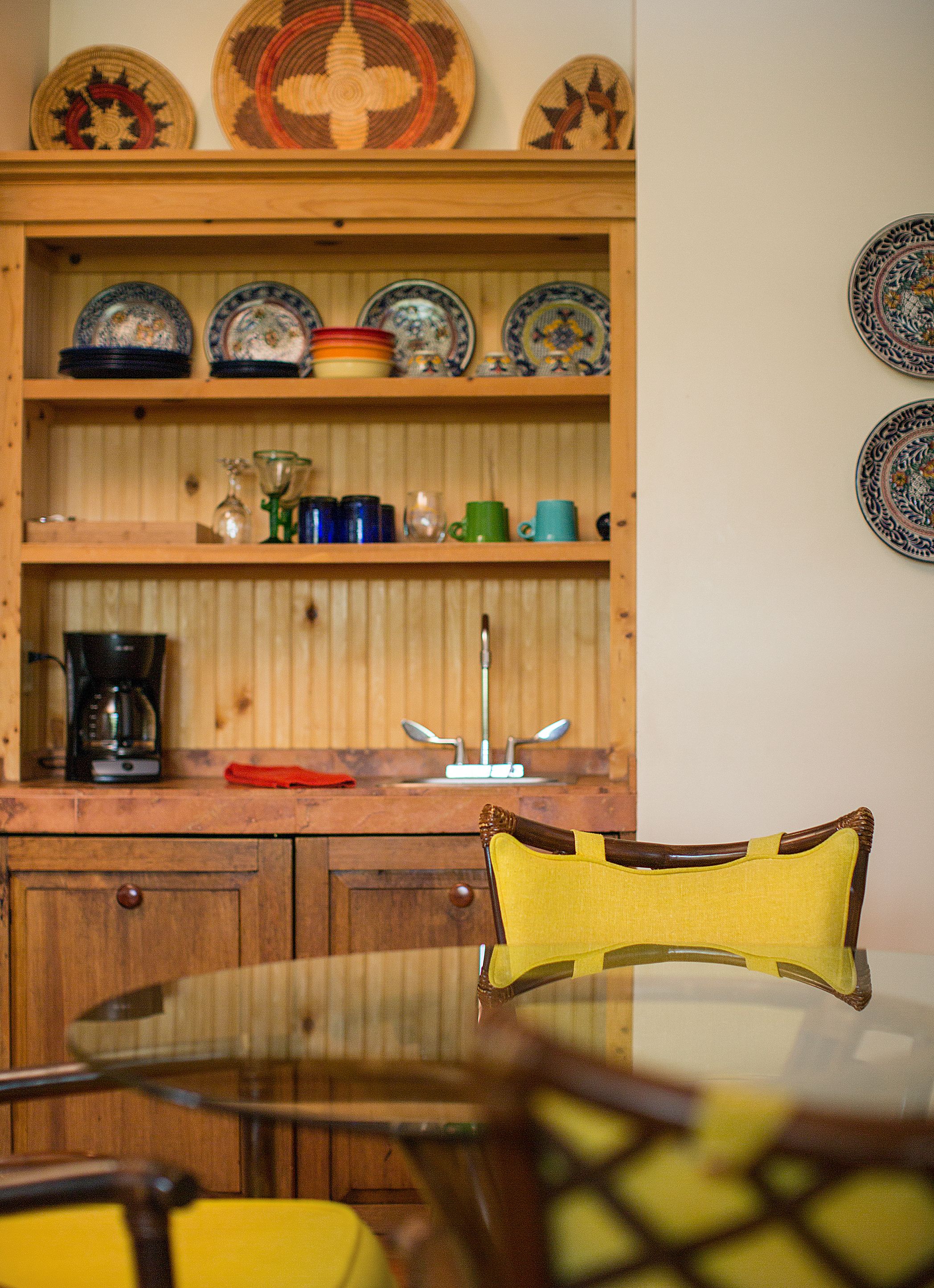 A kitchen with wooden cabinets, a coffee maker, and a sink.