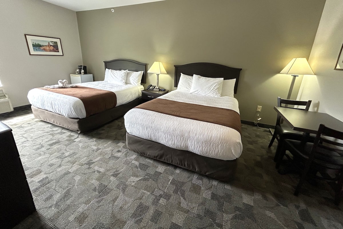 Una habitación de hotel con dos camas, un escritorio y una silla.