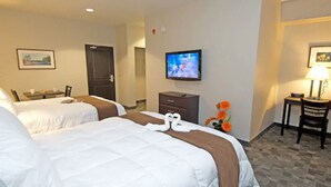 A hotel room with two beds, a television, a desk, and a chair. - Midland Inn & Suites (Midland)