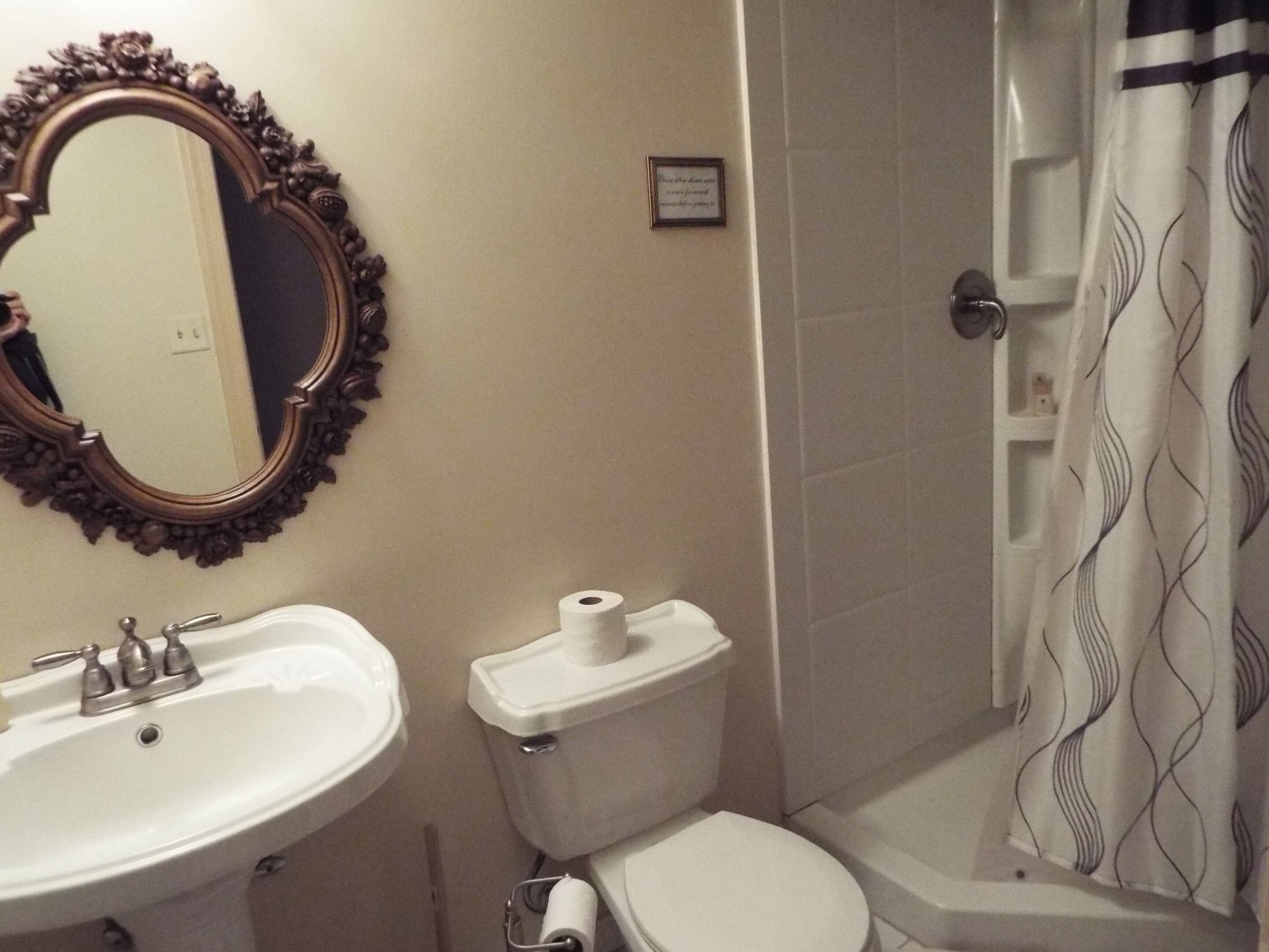 Un baño con lavamanos, inodoro y ducha.