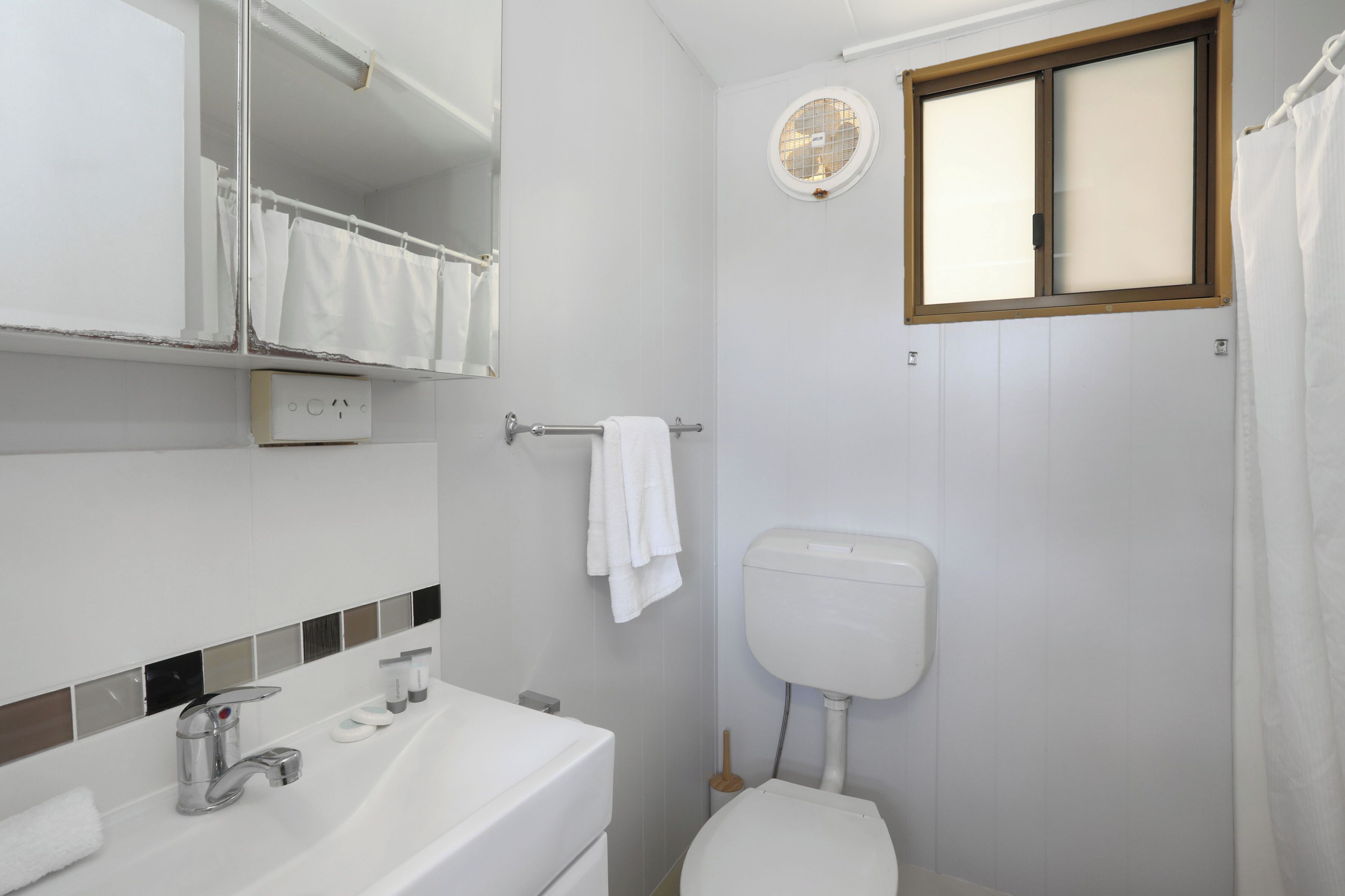 Ein Badezimmer mit Waschbecken, Spiegel und Toilette.
