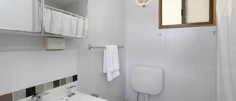 Ein Badezimmer mit Waschbecken, Spiegel und Toilette.