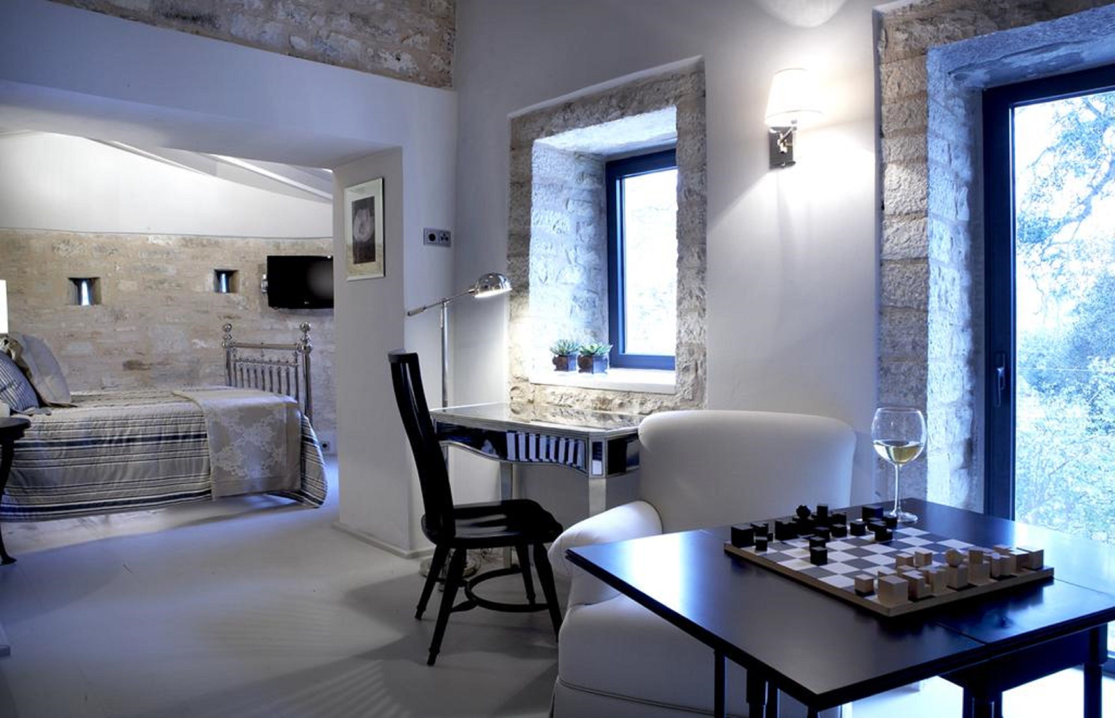 A room with a bed, a desk, a chair, and a chessboard.