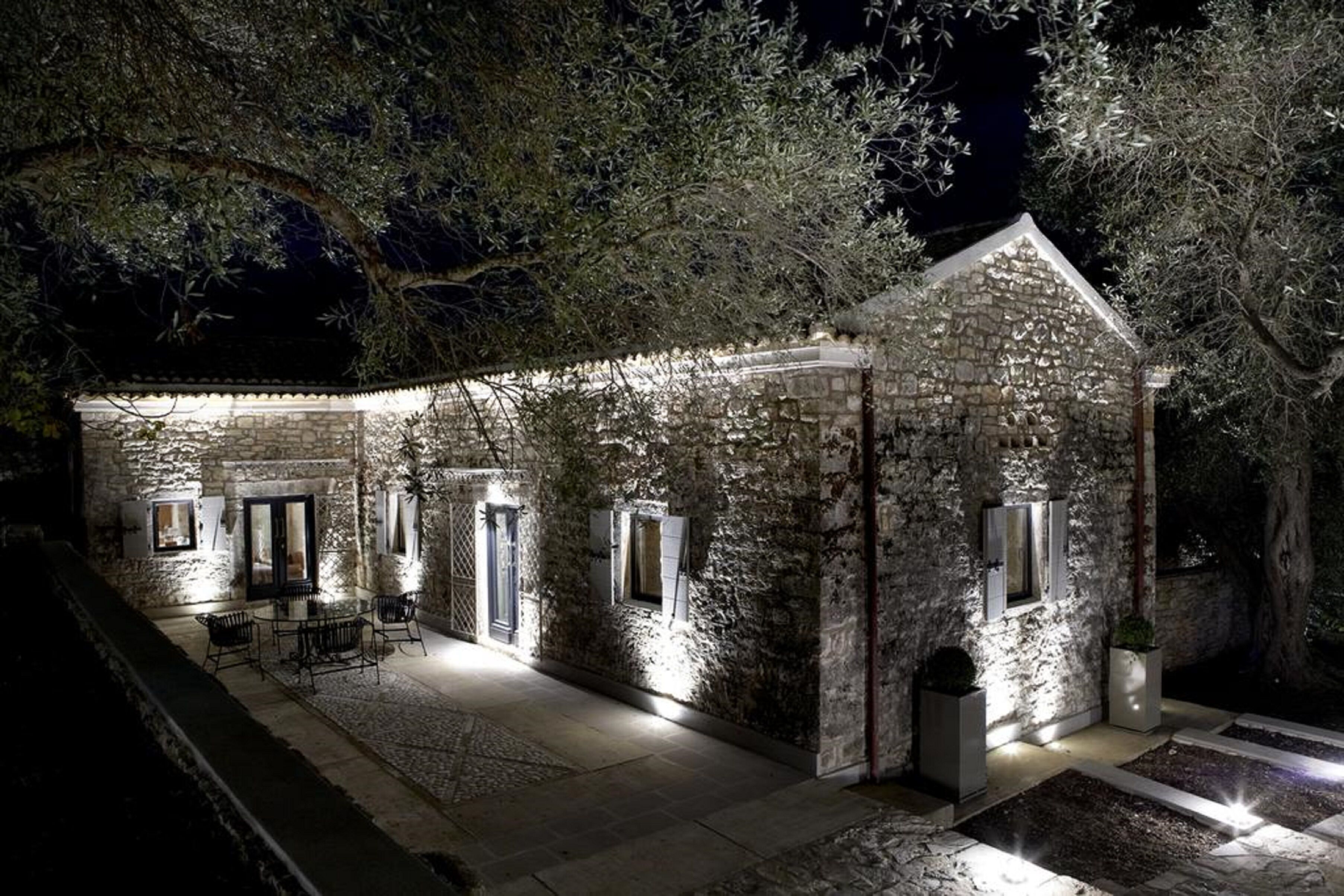 A stone building with a covered patio and outdoor seating.