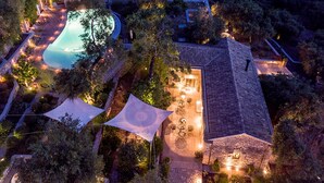 An aerial view of a property with a swimming pool, outdoor seating area, and a large tent-like structure. - Torri E Merli Hotel by GHH (Paxos)