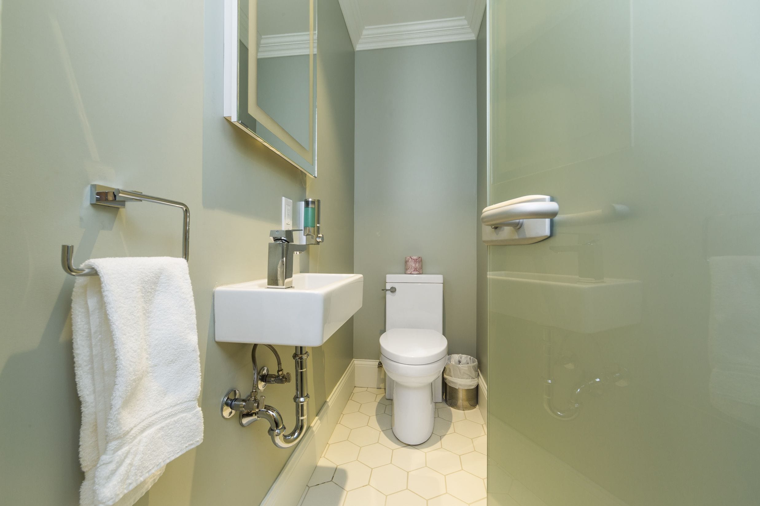 A bathroom with a white sink, toilet, and shower area.