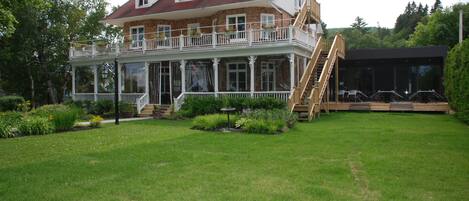A large, two-story house with a balcony and a covered outdoor area.