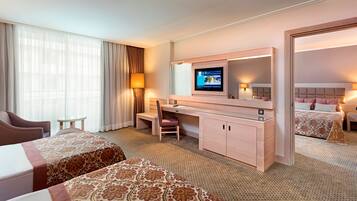 A hotel room with a bed, a desk, a chair, a TV, and a mirror.