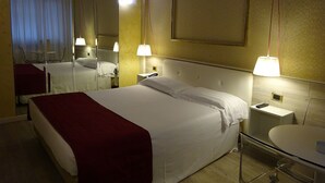 A hotel room with a large bed, bedside lamps, a mirror, a bedside table with a phone, and a round table with a chair. - 7MOTEL - SETTIMOTEL (Settimo Milanese)