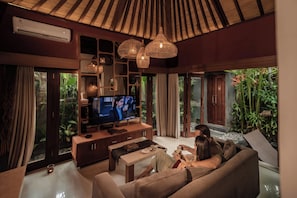 Una sala de estar moderna con televisor, sofá y mesa de centro.
