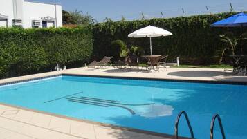 Piscina a l'aire lliure, para-sols i gandules