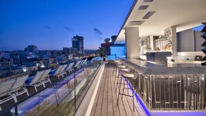 A rooftop bar with seating and a city view at dusk. - Hotel Valentina (St. Julian's)