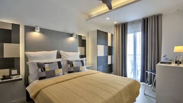 Una habitación de hotel moderna con una cama grande, un escritorio y un ventilador de techo.