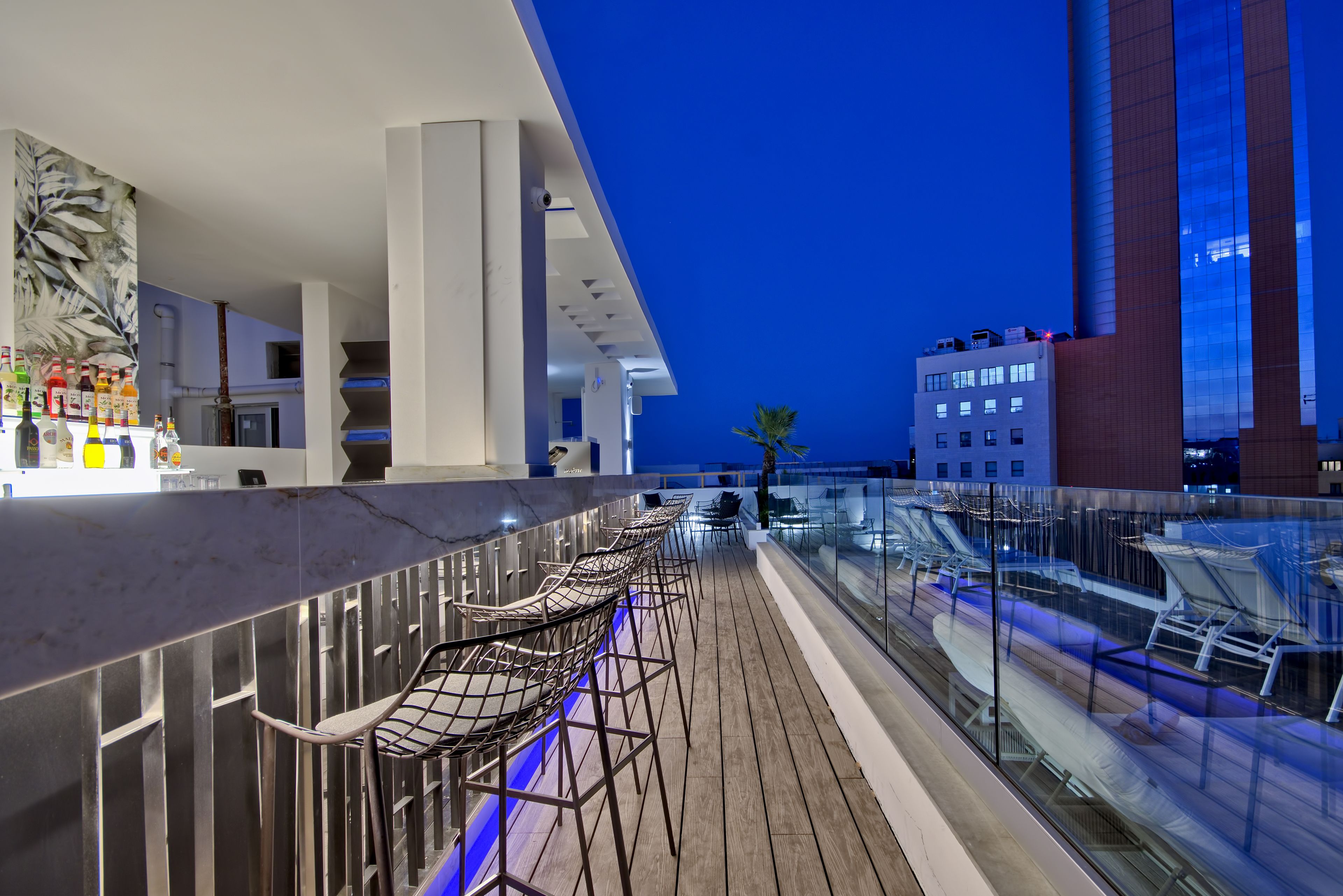Un espace bar moderne avec vue sur la piscine, comprenant un comptoir et des sièges.
