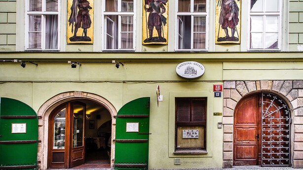 Un edificio con fachada verde, numerosas ventanas y un letrero que indica que es un negocio.