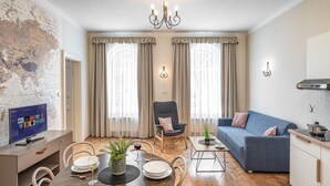 Una sala de estar moderna con comedor, un sofá, un televisor y una cocina.