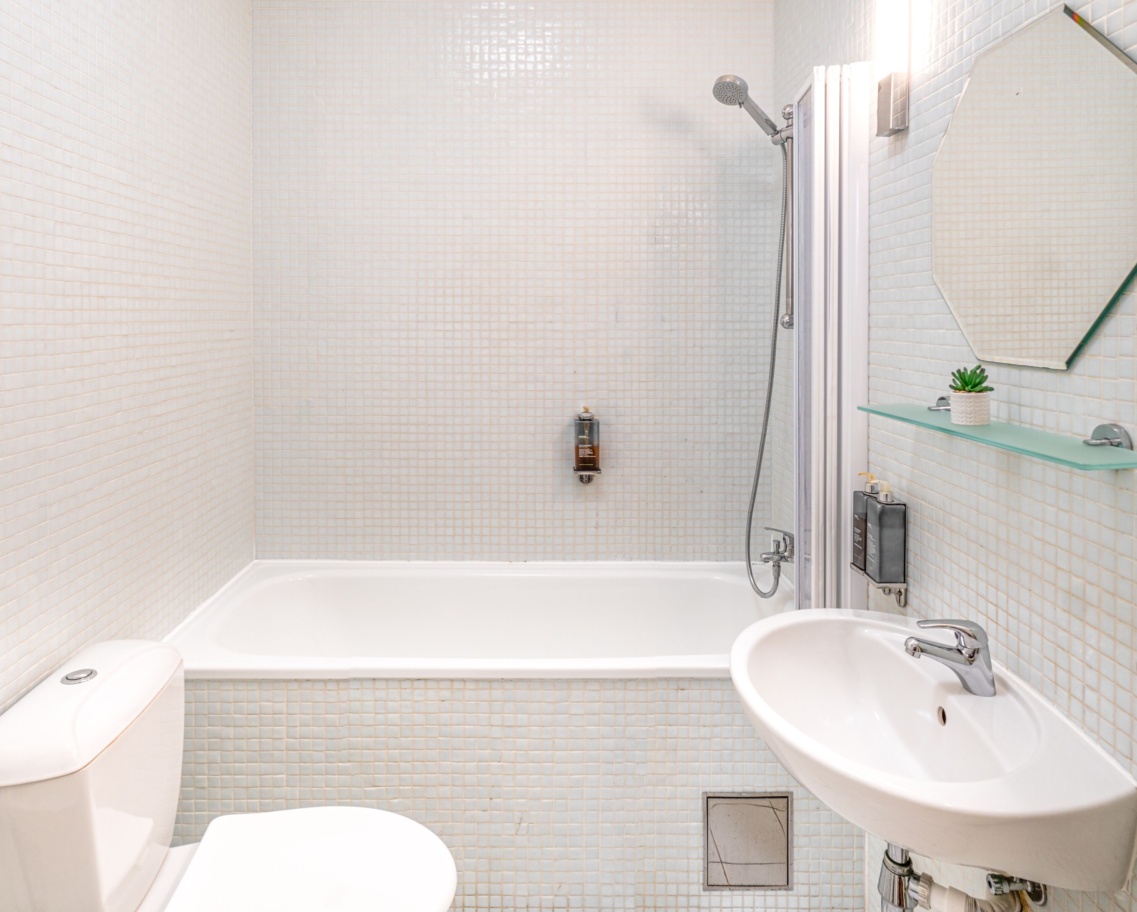 A modern bathroom with a bathtub, a sink, a toilet, and a shower.