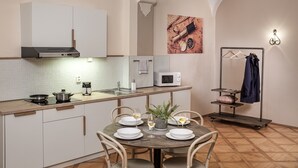 Una cocina moderna con armarios blancos, un microondas y una mesa de comedor lista para cuatro comensales.