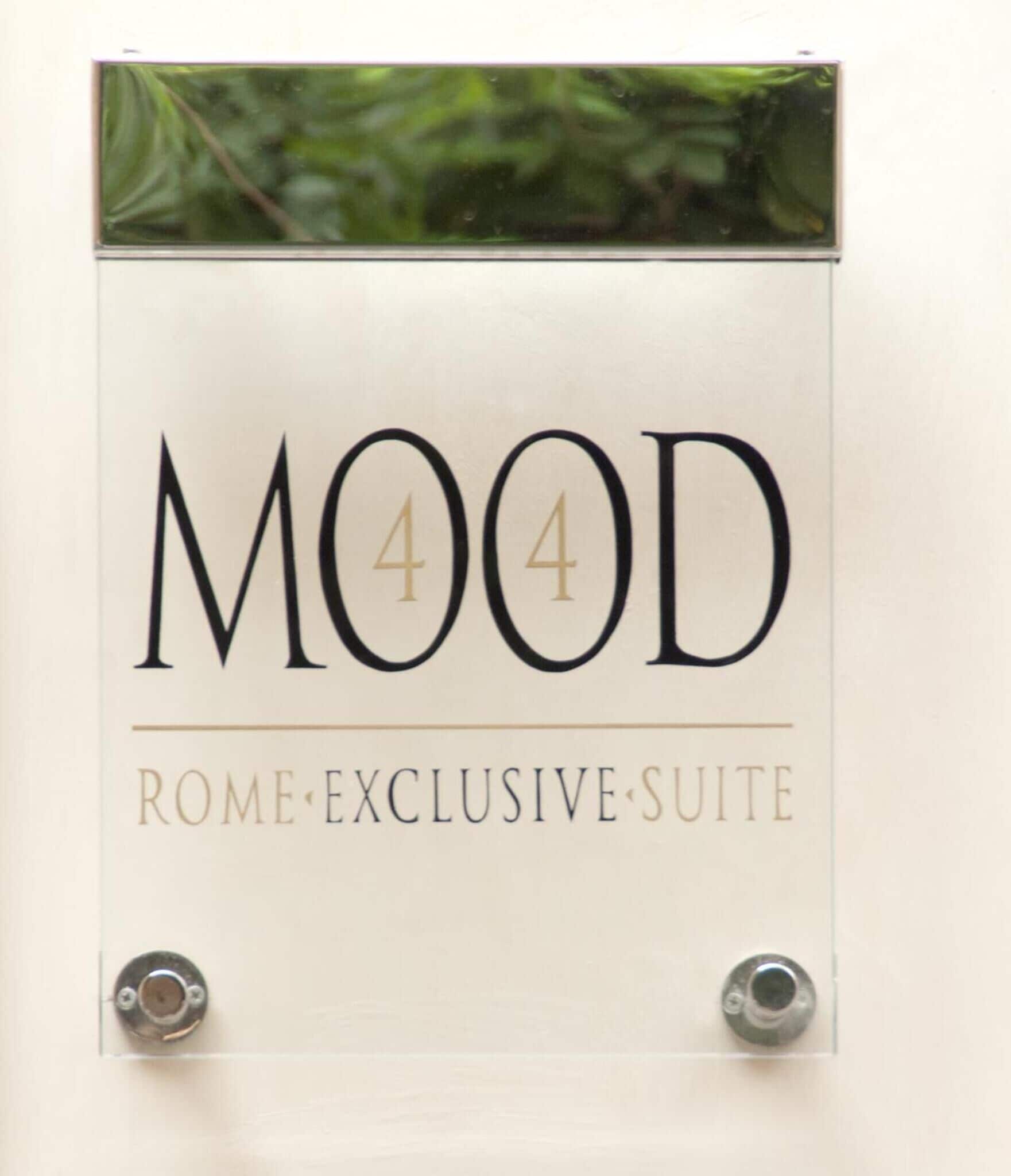 A sign for a "MOOD 44 Rome Exclusive Suite" with a clear, elegant design.