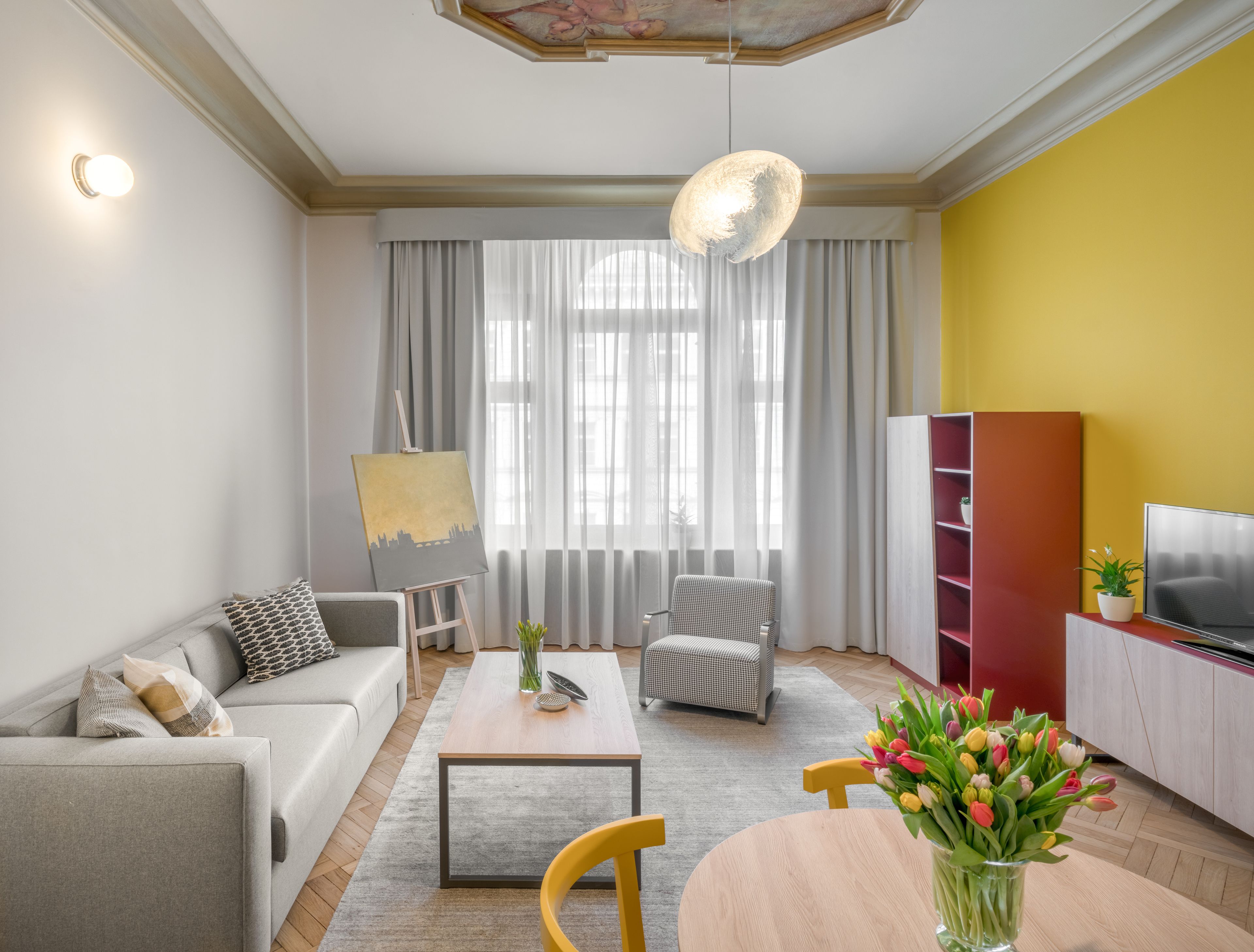 A modern living room with a sofa, a coffee table, a chair, a TV stand, and a bookshelf.