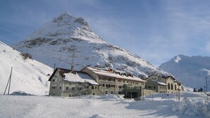 A snow-covered mountain with a hotel in the foreground.