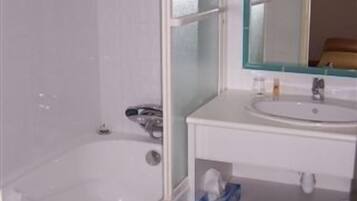 Un bany amb banyera, un lavabo i un mirall.