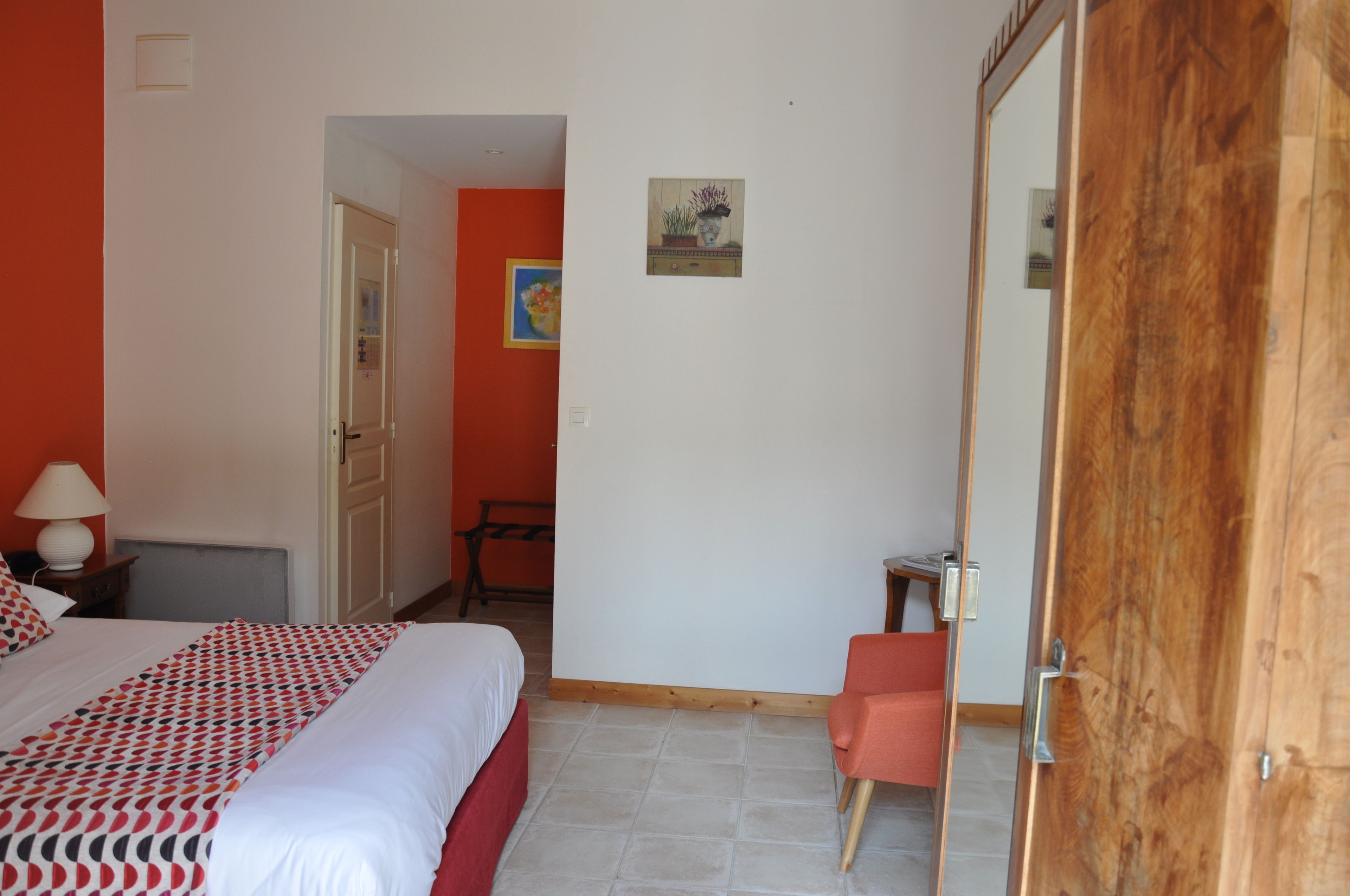 Una camera d'albergo con un letto, una scrivania, una sedia e una porta.