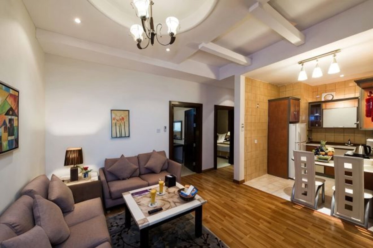 A living room with a sofa, coffee table, and a dining area with chairs and a table.
