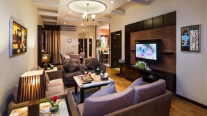 Een moderne woonkamer met een flatscreen televisie, comfortabele zitmogelijkheden en een decoratieve wand.
