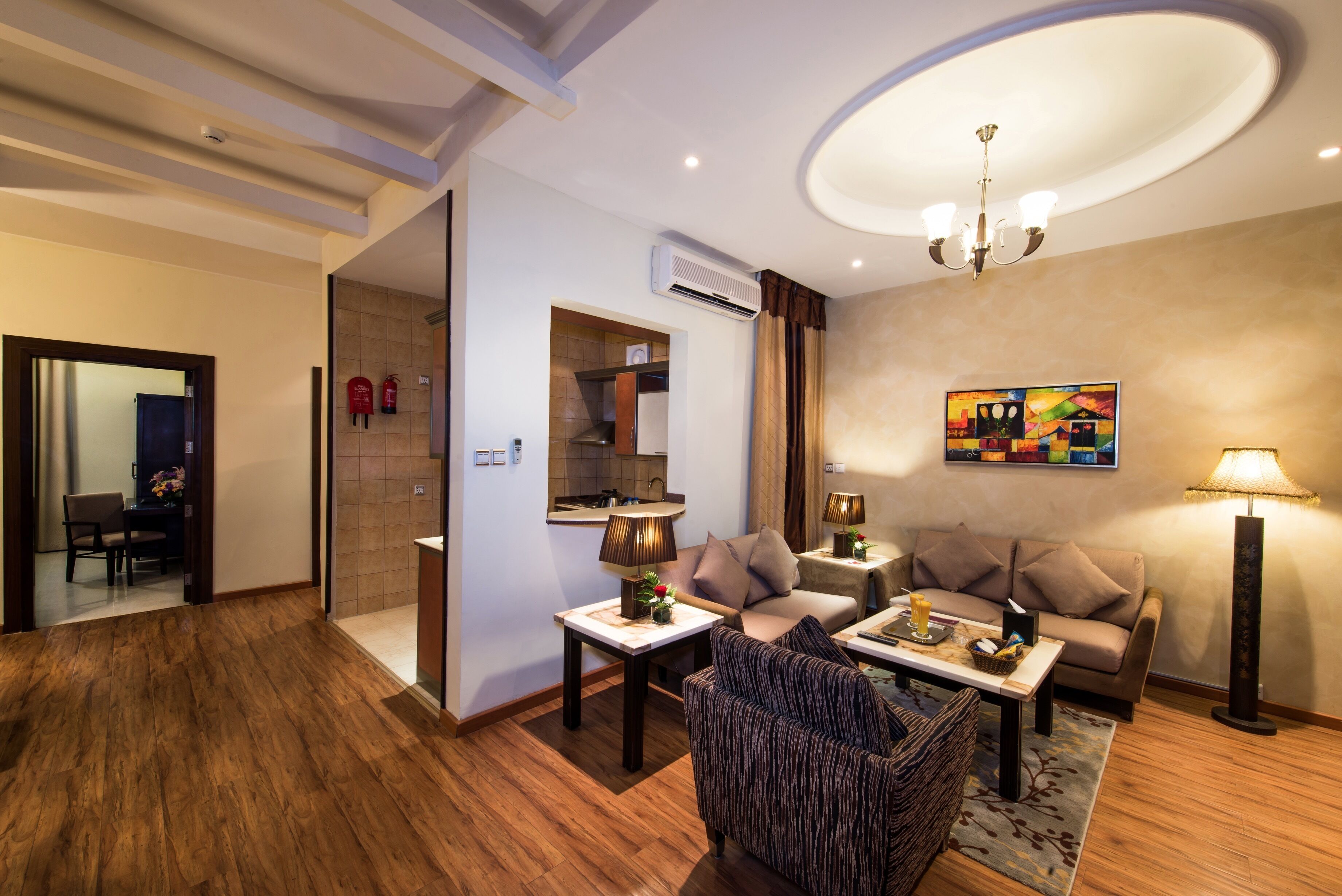 A modern living room with a sofa, armchairs, a coffee table, and a dining area with a table and chairs.