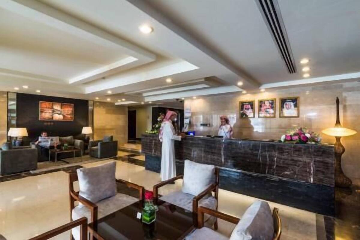 Un vestíbulo de hotel con mostrador de recepción, zona de estar y obras de arte en las paredes.