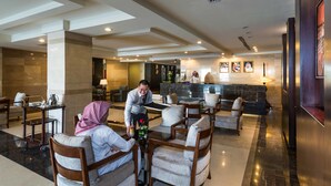 A hotel lobby with a reception desk, seating area, and a bar. - Boudl Rass (Ar Rass)