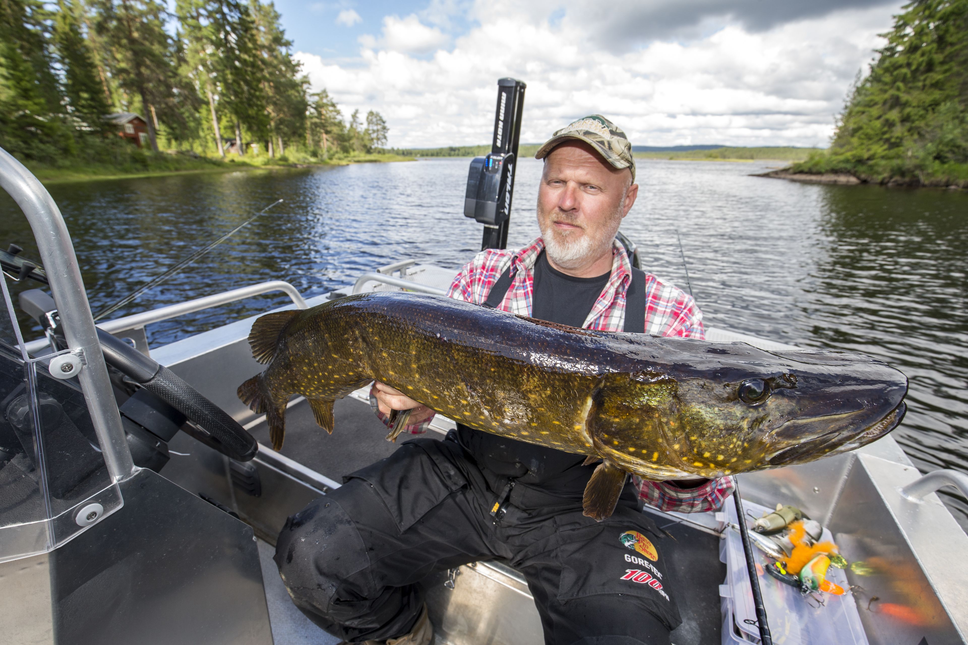 A man holding a large fish on a boat.