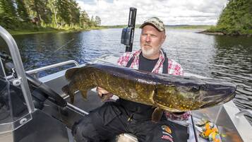 A man holding a large fish on a boat.